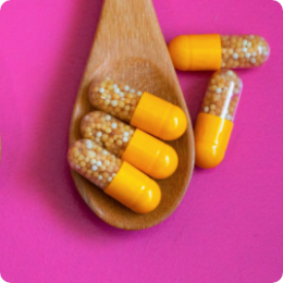 Image of Vitamin C in a capsule laying on a wooden spoon